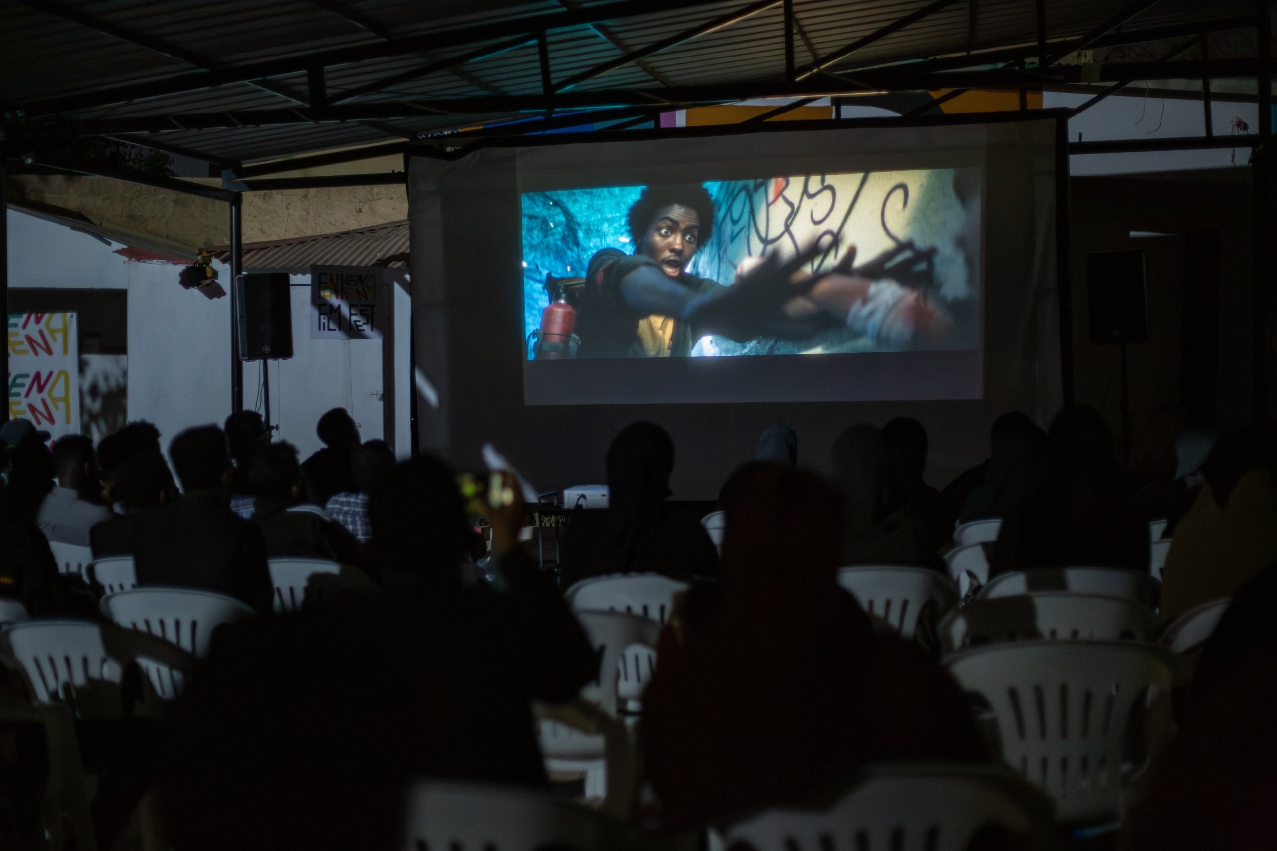 The audience sits in the dark in front of the big screen during a screening