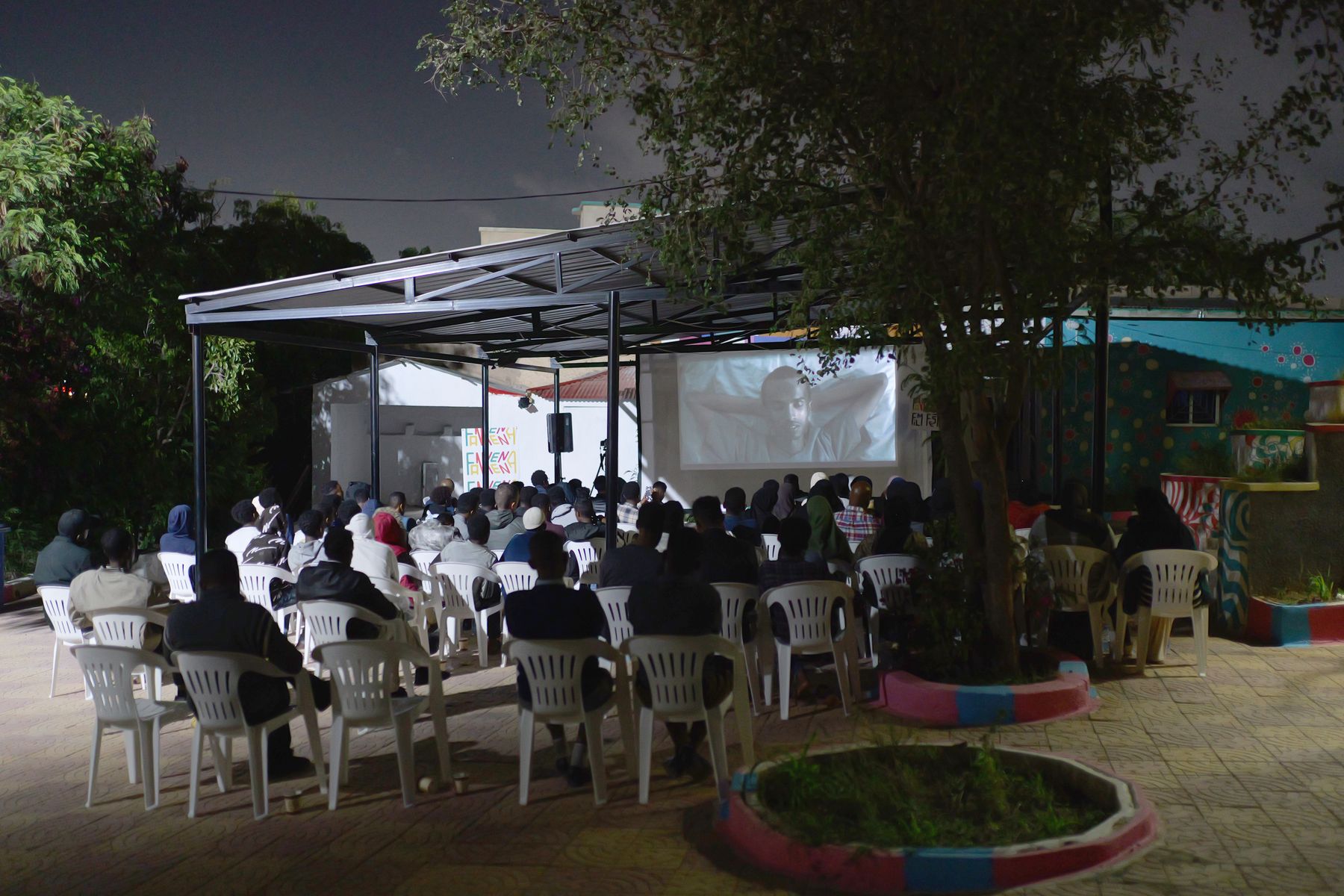Rows of chairs facing the screen in the Fankeenna courtyard at night