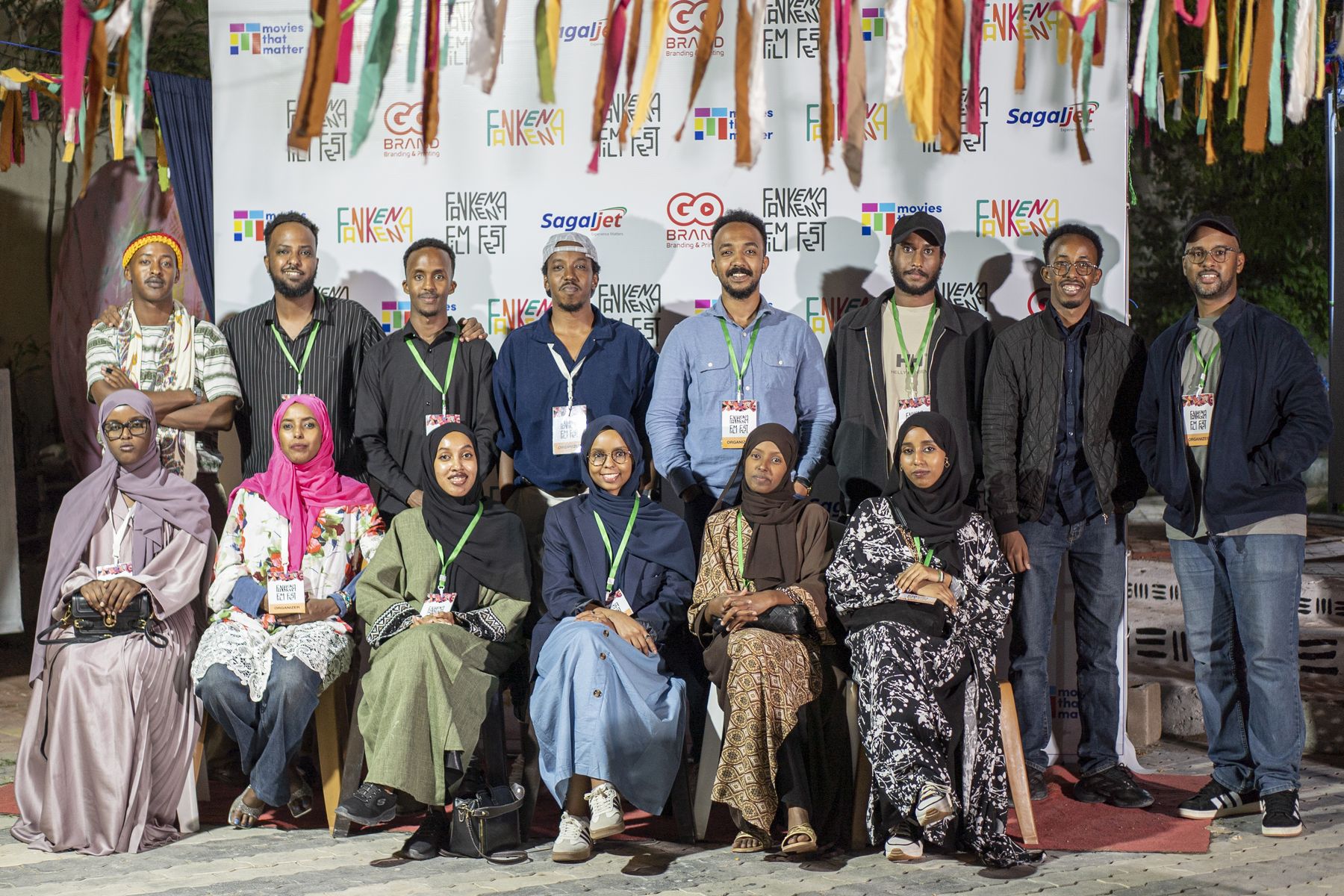The festival team and volunteers in front of the festival wall